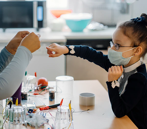 Педагог рассказывает, используя примеры, ученице о электричестве. Девочка внимательно смотрит.